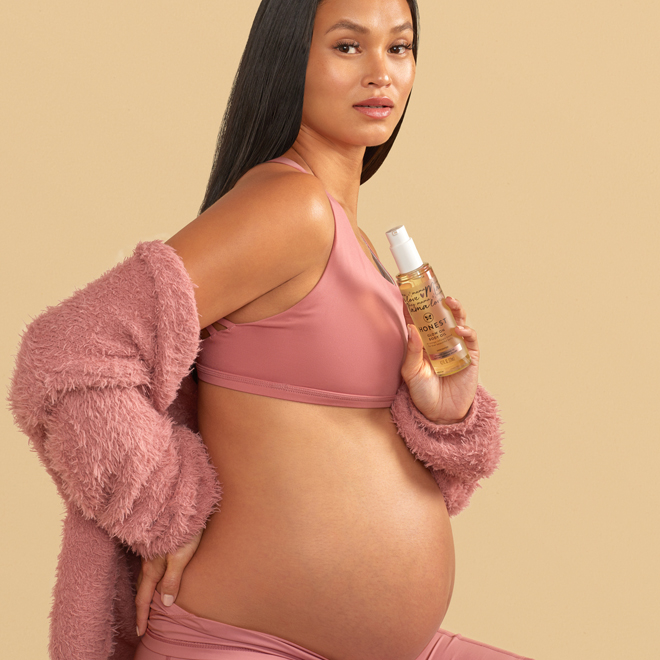 Honest Mama holding glow on body oil