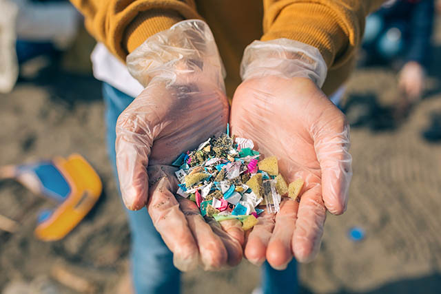 Person holding sand mixed with microplastics