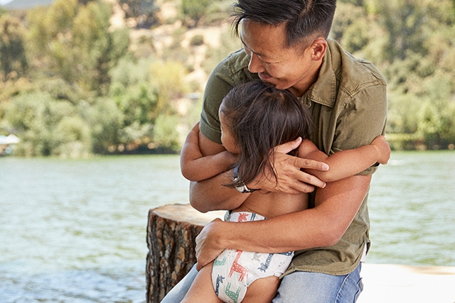 Dad hugs baby girl at the lake